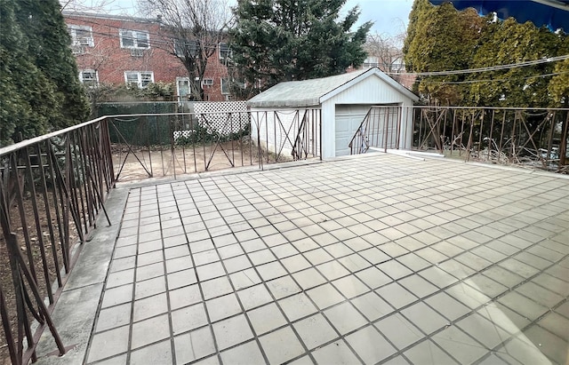 exterior space with a detached garage, fence, and an outbuilding