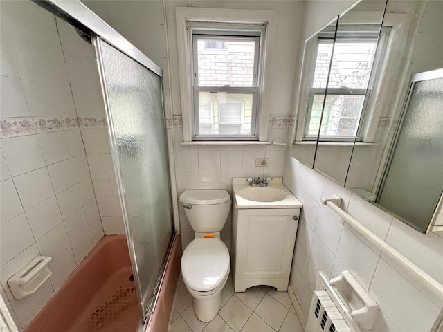 full bathroom featuring an enclosed shower, tile walls, and plenty of natural light