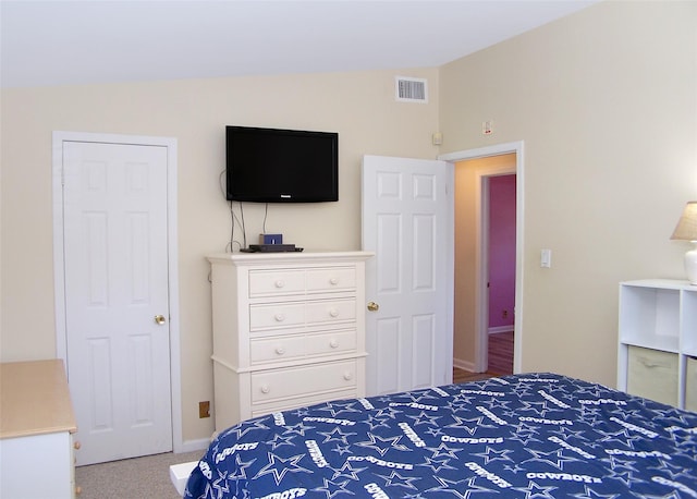 carpeted bedroom with baseboards, visible vents, and vaulted ceiling