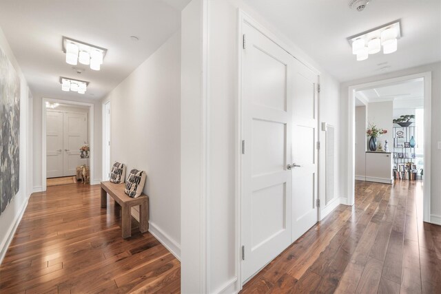 corridor with baseboards and dark wood-type flooring