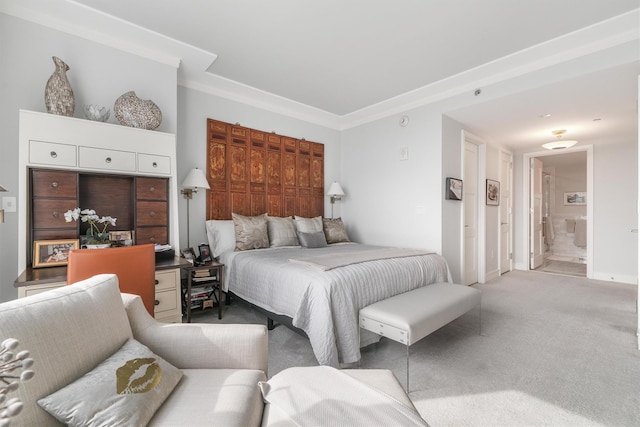 carpeted bedroom with ornamental molding and ensuite bath