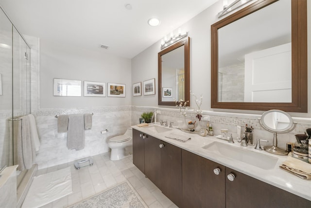bathroom with a sink, tile walls, toilet, and visible vents