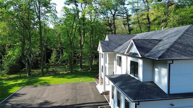 412 Mill River Rd, Oyster Bay, NY 11771 - view of property exterior featuring roof with shingles, stucco siding, and a lawn