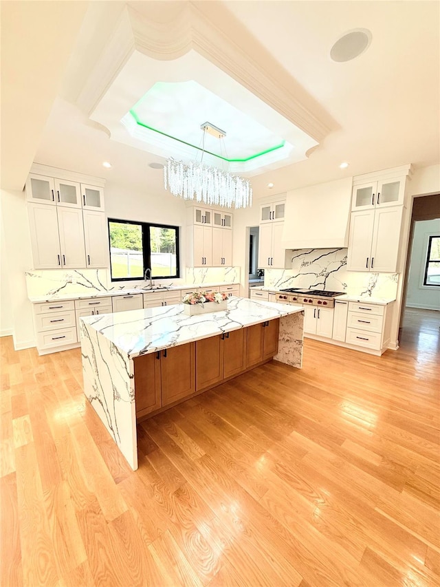 412 Mill River Rd, Oyster Bay, NY 11771 - kitchen with white cabinets, a tray ceiling, and tasteful backsplash