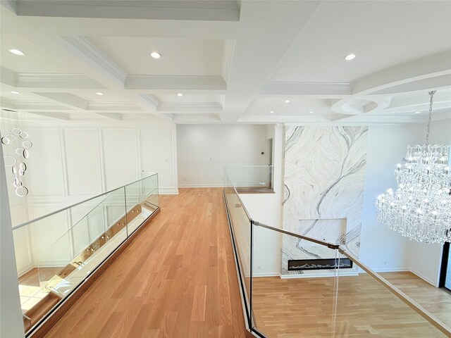 412 Mill River Rd, Oyster Bay, NY 11771 - hallway with beamed ceiling, light wood finished floors, a chandelier, coffered ceiling, and recessed lighting