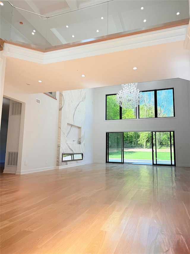 412 Mill River Rd, Oyster Bay, NY 11771 - unfurnished living room with visible vents, light wood finished floors, an inviting chandelier, a high ceiling, and recessed lighting