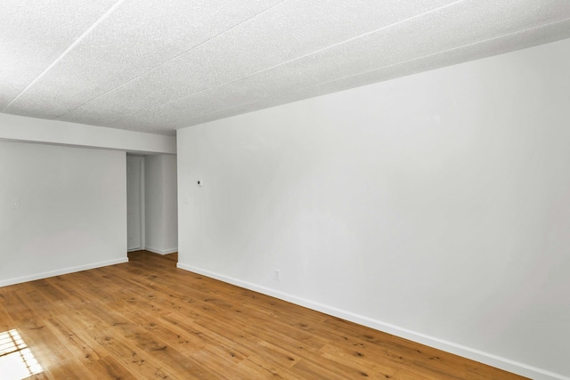 57-15 69th Ln # 2, Maspeth, NY 11378 - spare room featuring light wood-type flooring, baseboards, and a textured ceiling