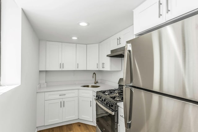 57-15 69th Ln # 2, Maspeth, NY 11378 - kitchen with freestanding refrigerator, a sink, range with gas stovetop, under cabinet range hood, and white cabinetry