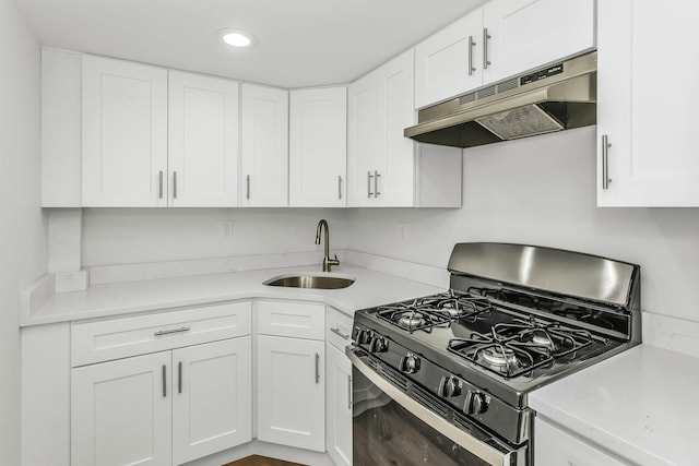 57-15 69th Ln # 2, Maspeth, NY 11378 - kitchen with gas range, a sink, under cabinet range hood, light countertops, and white cabinets