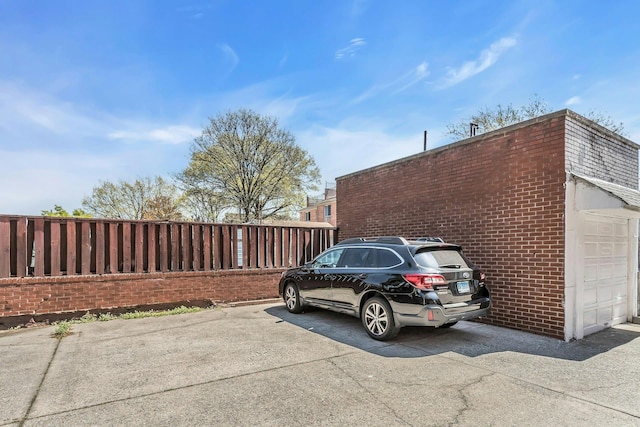 57-15 69th Ln # 2, Maspeth, NY 11378 - view of side of home with fence, brick siding, and a garage