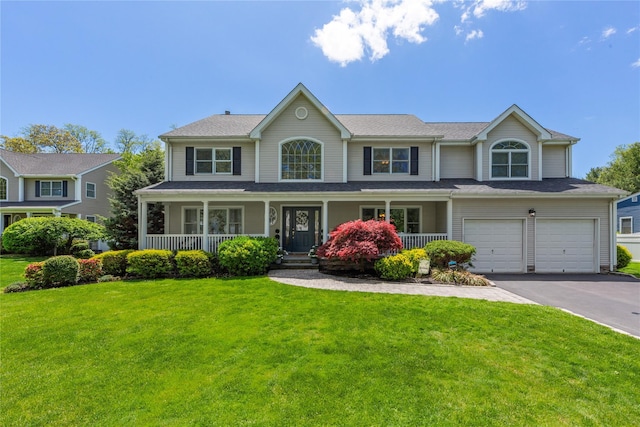 view of front facade featuring driveway, a garage, a front lawn, and covered porch