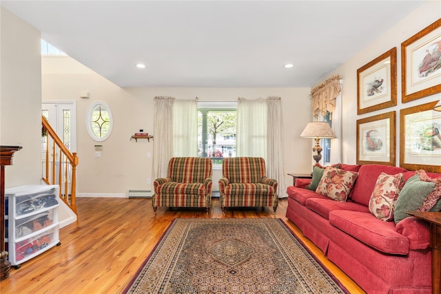 living area with wood finished floors, baseboards, recessed lighting, baseboard heating, and stairway