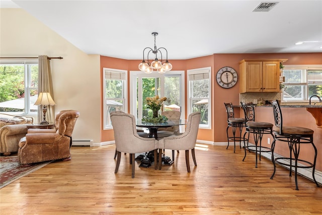 dining area with baseboard heating, light wood-type flooring, a chandelier, recessed lighting, and baseboards