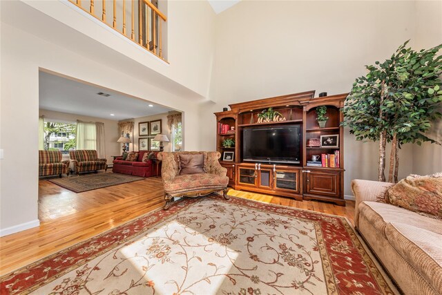 living area with wood finished floors and a high ceiling