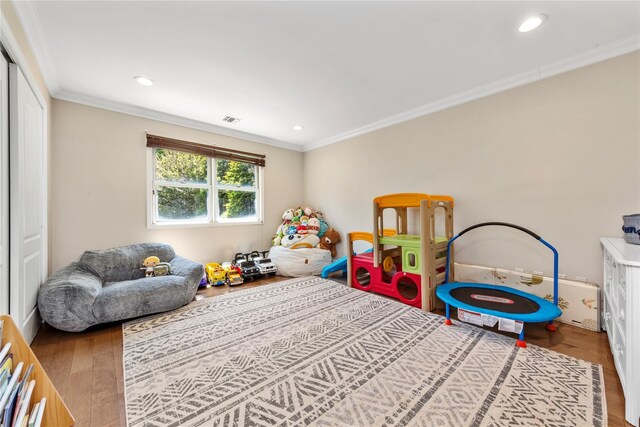 rec room featuring wood finished floors, ornamental molding, and recessed lighting