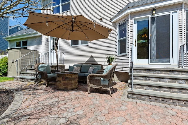 view of patio featuring entry steps and an outdoor living space with a fire pit