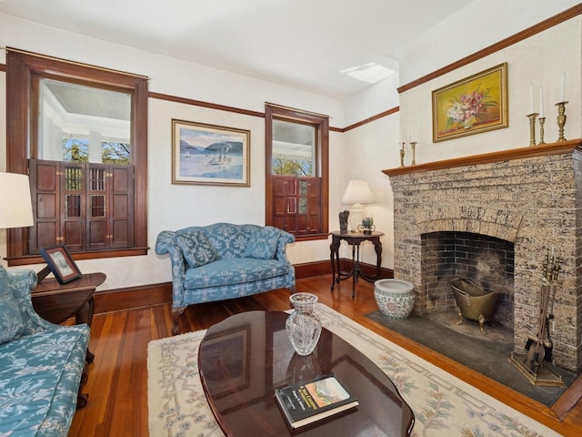 living area with baseboards, a healthy amount of sunlight, hardwood / wood-style flooring, and a fireplace