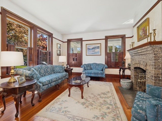 living room with wood-type flooring and a brick fireplace