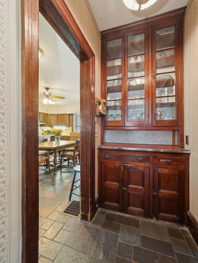 bar with stone tile floors and a ceiling fan