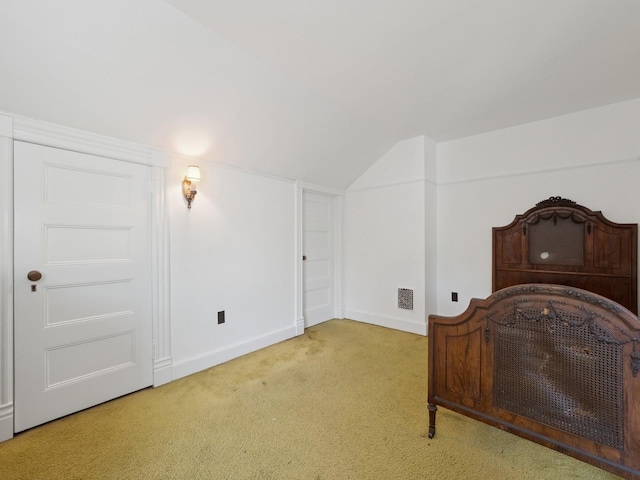 bedroom with visible vents, baseboards, carpet, and lofted ceiling