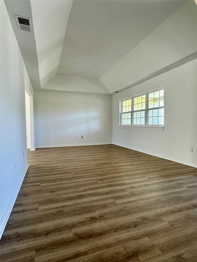 1403 Pebble Beach Path, Riverhead, NY 11901 - unfurnished room featuring dark wood-style flooring, baseboards, a tray ceiling, and lofted ceiling