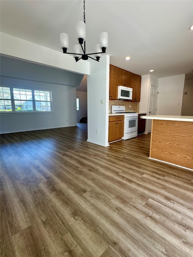 1403 Pebble Beach Path, Riverhead, NY 11901 - unfurnished living room with dark wood-type flooring, baseboards, recessed lighting, and a chandelier
