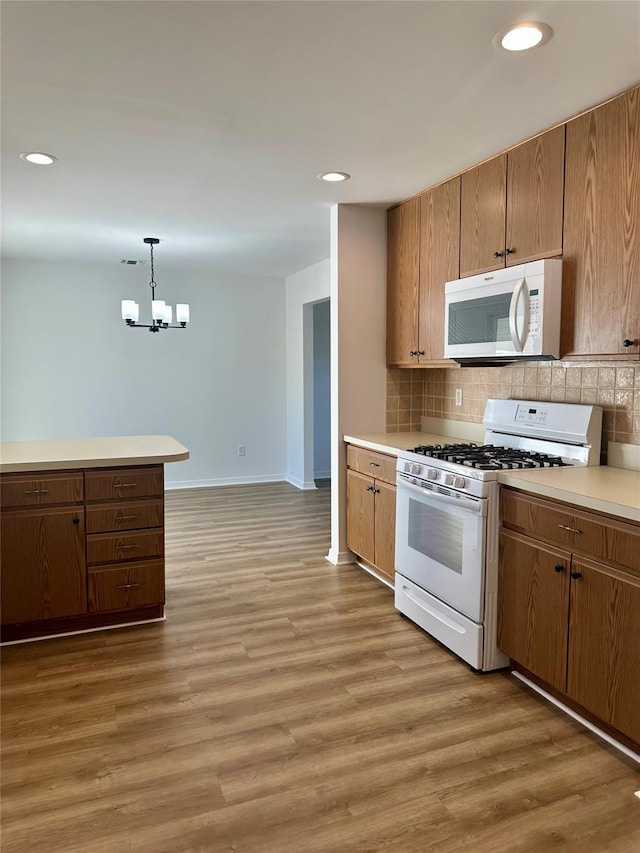 1403 Pebble Beach Path, Riverhead, NY 11901 - kitchen with white appliances, a chandelier, backsplash, light countertops, and recessed lighting