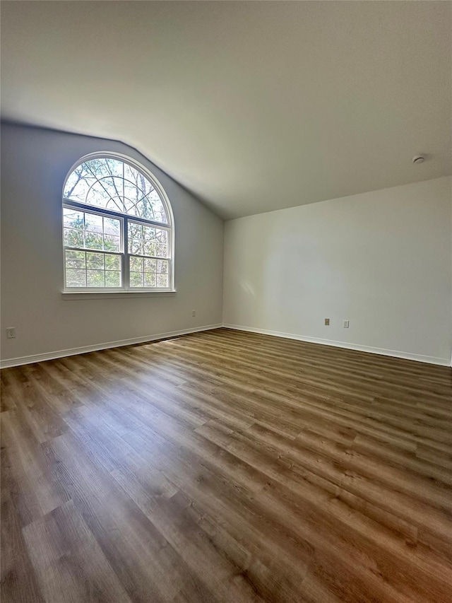 1403 Pebble Beach Path, Riverhead, NY 11901 - spare room with lofted ceiling, dark wood-type flooring, and baseboards
