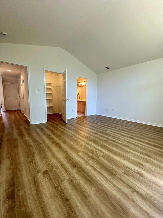 1403 Pebble Beach Path, Riverhead, NY 11901 - unfurnished bedroom featuring wood finished floors, vaulted ceiling, a spacious closet, baseboards, and a closet