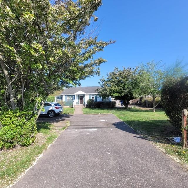 view of front facade with a front lawn and aphalt driveway