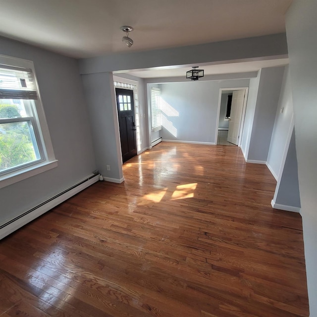 foyer featuring baseboards, baseboard heating, and wood finished floors