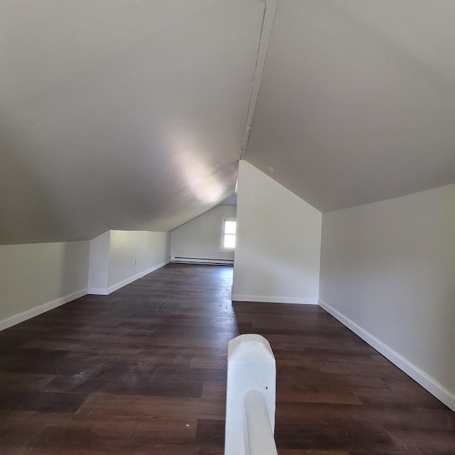 additional living space with baseboards, a baseboard heating unit, dark wood finished floors, and lofted ceiling