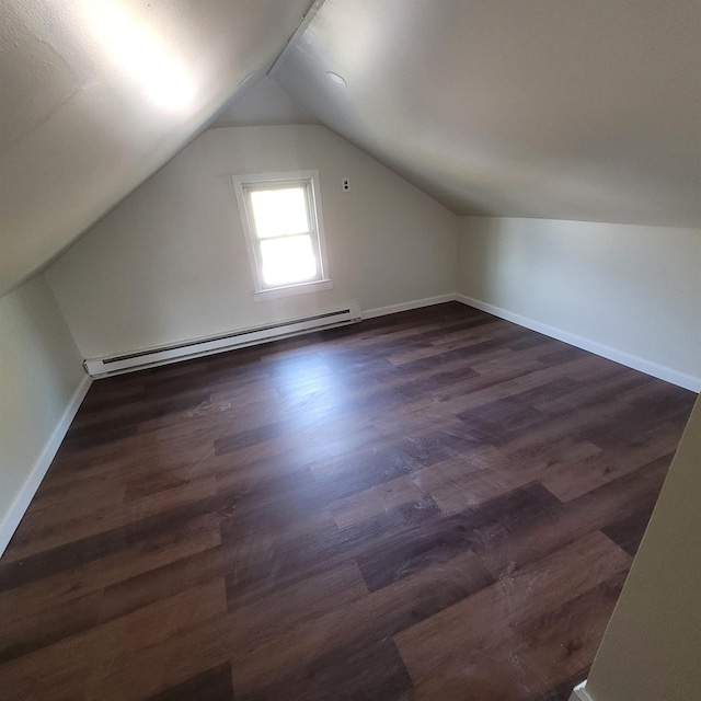 additional living space with baseboards, lofted ceiling, dark wood-type flooring, and a baseboard radiator