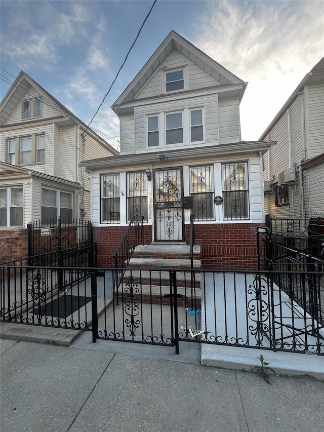 view of front of home featuring brick siding and a fenced front yard