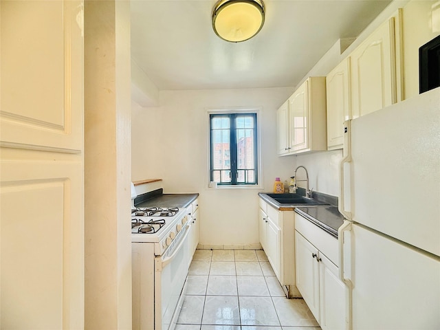 kitchen with a sink, light tile patterned floors, white appliances, and white cabinetry