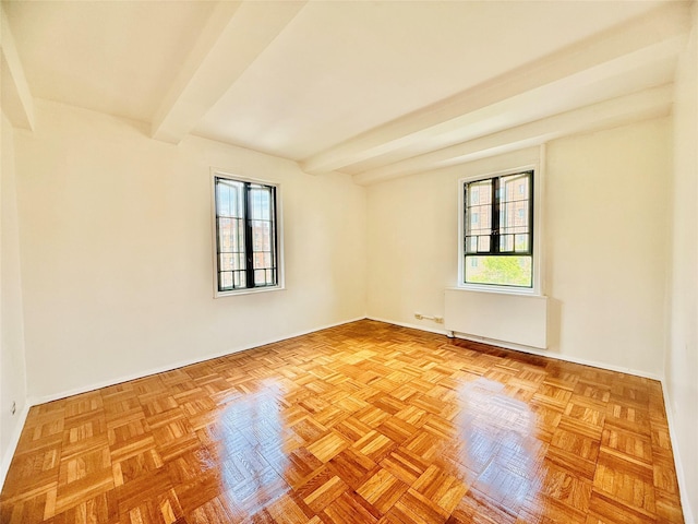 unfurnished room with baseboards, beam ceiling, a healthy amount of sunlight, and radiator