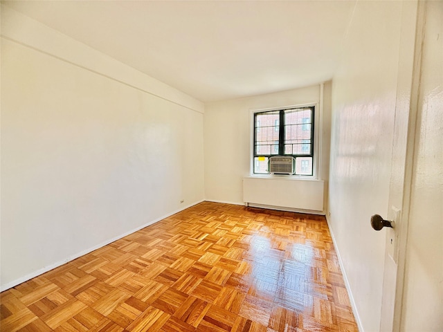 empty room featuring baseboards, cooling unit, and radiator heating unit