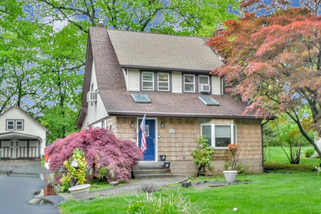 view of front facade featuring a front yard, a shingled roof, cooling unit, and entry steps