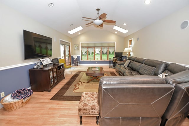 living area with a skylight, light wood-type flooring, ceiling fan, lofted ceiling, and recessed lighting