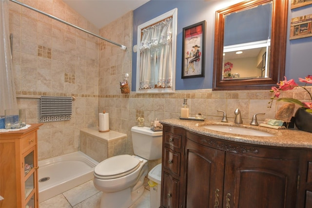 full bathroom featuring tiled shower, toilet, vanity, tile walls, and tasteful backsplash