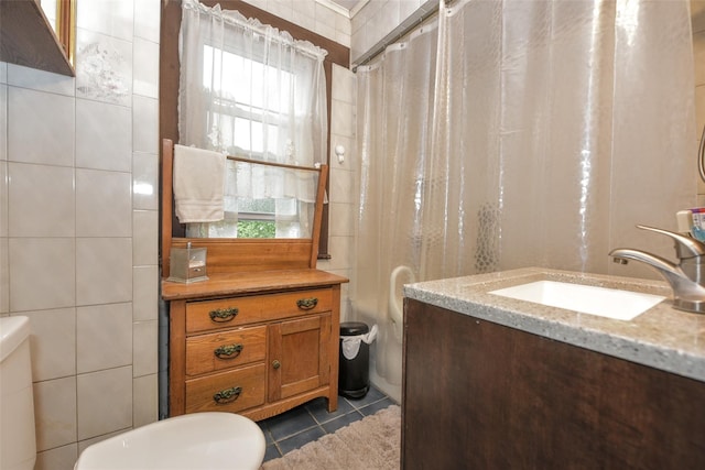 bathroom with toilet, tile patterned flooring, vanity, a shower with shower curtain, and tile walls