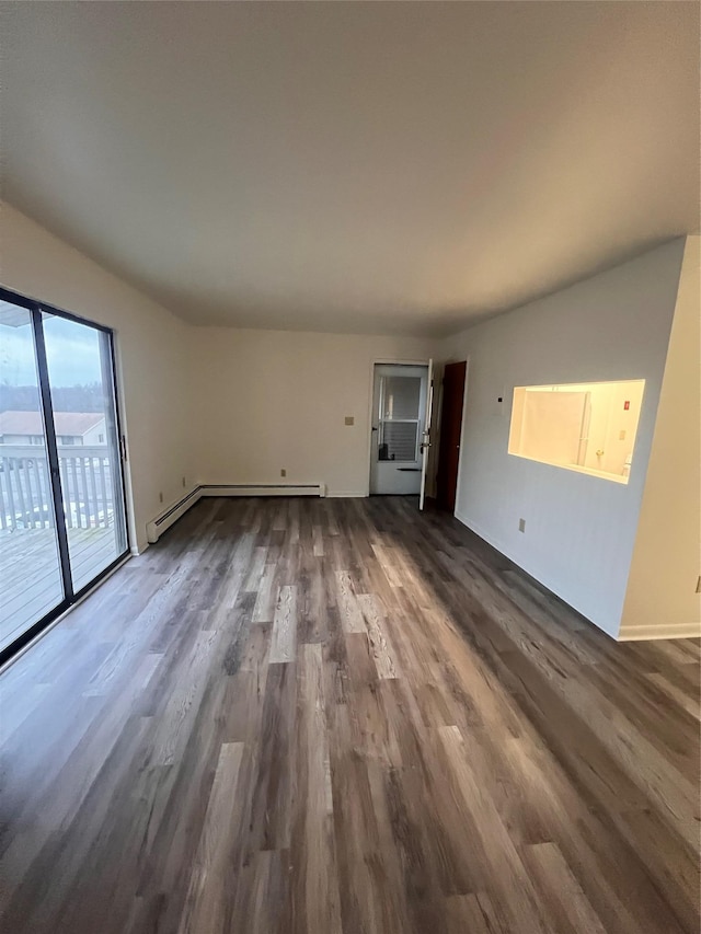 unfurnished living room featuring baseboards, baseboard heating, and dark wood finished floors