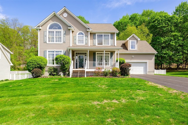 view of front of house with covered porch, driveway, a garage, and roof with shingles