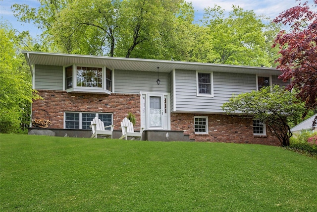 back of house featuring a yard and brick siding