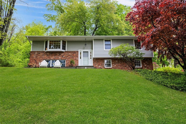 rear view of house with brick siding and a lawn