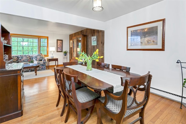 dining area with light wood-style floors and a baseboard heating unit