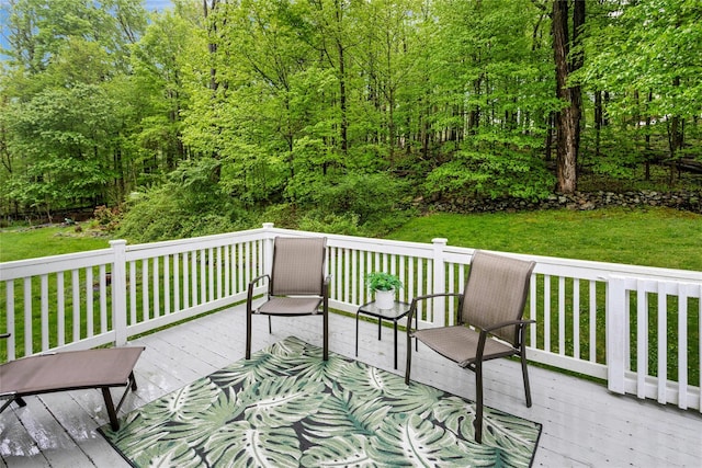 wooden deck featuring a lawn
