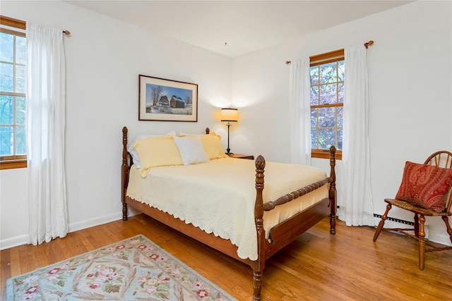 bedroom with light wood finished floors and baseboards