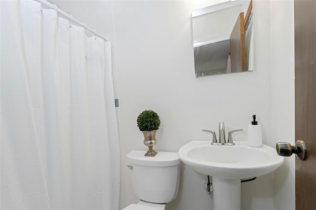 full bathroom featuring toilet and curtained shower
