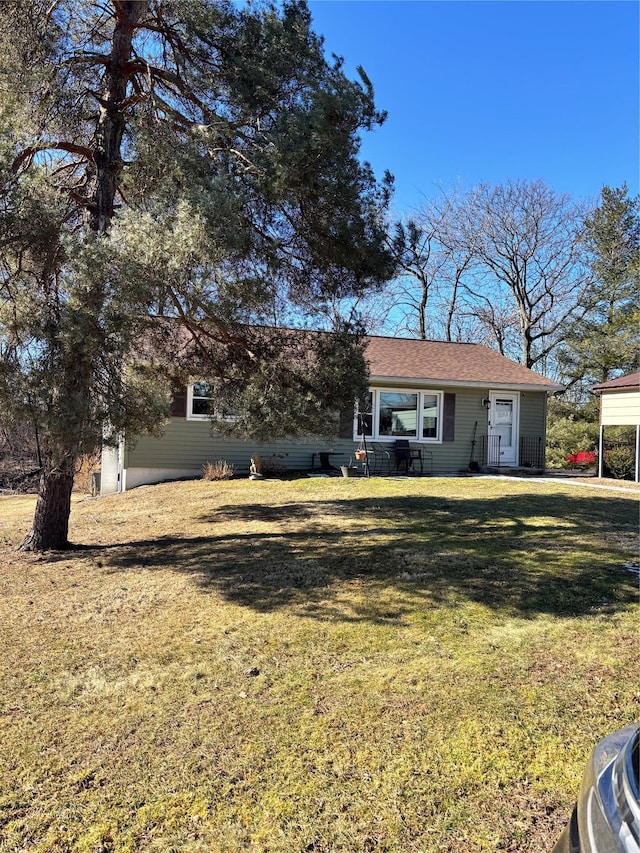 view of front of home with a front yard and a carport